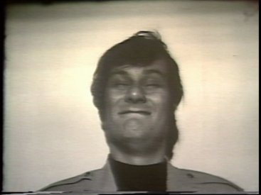 Still from Sequence 14 of Idea Demonstrations. Mike Parr stares into a bright light until he blinks.