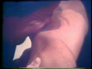 Still from Sequence 22 of Idea Demonstrations. Peter Kennedy bites Mike Parr's arm.